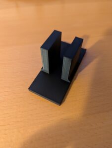 Plastic bracket with a slot for plywood to fit between and a base.