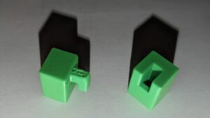 A closeup of just the two fastener objects. The left has a cube with a square finger coming out one side, while the right is a cube with a cutout that the finger fits into. 