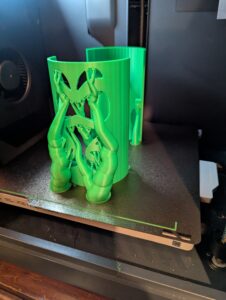 A photo of one of the shades in the 3d printer while it prints. A large number of tree supports are visible. 